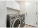 Convenient laundry room with modern washer and dryer, plus cabinet storage and a door to outside at 6539 W Briles Rd, Phoenix, AZ 85083