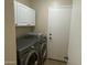 Functional laundry room with modern washer and dryer, ample storage, and easy access to other areas at 6539 W Briles Rd, Phoenix, AZ 85083