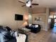 Inviting living room with comfortable seating, a ceiling fan, and a wall-mounted TV for relaxing entertainment at 6539 W Briles Rd, Phoenix, AZ 85083