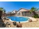 Backyard view of the fenced in, in-ground pool surrounded by rock landscaping at 6539 W Briles Rd, Phoenix, AZ 85083