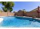 Backyard view of a refreshing in-ground swimming pool and mature landscaping at 6539 W Briles Rd, Phoenix, AZ 85083