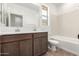 Bathroom featuring double sinks, dark cabinets, a large mirror, and a bathtub at 7417 E Hackamore Ln, San Tan Valley, AZ 85143