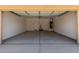 Interior view of the empty two-car garage featuring painted drywall and concrete flooring at 7417 E Hackamore Ln, San Tan Valley, AZ 85143