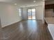 Open-concept living room features wood-look tile flooring, a sliding glass door, and recessed lighting at 7417 E Hackamore Ln, San Tan Valley, AZ 85143