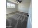 An airy bedroom features neutral carpet, a ceiling fan, and view of the outdoors at 7637 E Akron St, Mesa, AZ 85207