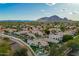 Expansive aerial view showcases a lush community nestled against a scenic mountain backdrop at 7678 E Cactus Wren Rd, Scottsdale, AZ 85250