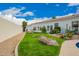 Green backyard with large rocks, desert landscaping, and view of rear exterior of house at 7678 E Cactus Wren Rd, Scottsdale, AZ 85250