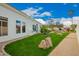 Green backyard with large rocks, desert landscaping, and view of rear exterior of house at 7678 E Cactus Wren Rd, Scottsdale, AZ 85250