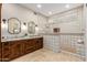 Bright bathroom featuring double vanities, granite countertops, and tiled shower at 7678 E Cactus Wren Rd, Scottsdale, AZ 85250