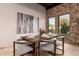 Elegant dining room features stone accent wall, modern chairs, and natural light at 7678 E Cactus Wren Rd, Scottsdale, AZ 85250
