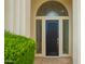 Front door with a large arched window above the entryway with beautiful desert landscaping at 7678 E Cactus Wren Rd, Scottsdale, AZ 85250