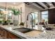 Kitchen island with stainless steel sink and faucet and an open plan to the living room at 7678 E Cactus Wren Rd, Scottsdale, AZ 85250