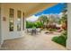 Covered patio with dining set and lush landscaping including palm trees and colorful flowers at 7678 E Cactus Wren Rd, Scottsdale, AZ 85250