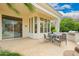 Spacious covered patio with dining set, outdoor kitchen, and lush tropical landscaping at 7678 E Cactus Wren Rd, Scottsdale, AZ 85250
