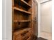Custom wood shelves, cabinets, and drawers for storage with matte black hardware, near doorway at 7678 E Cactus Wren Rd, Scottsdale, AZ 85250