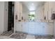 Bathroom vanity with dual sinks, large mirror, white cabinetry and a tiled shower at 7703 E Overlook Dr, Scottsdale, AZ 85255