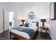 A bedroom with a modern wood frame bed and side tables under wall art at 7703 E Overlook Dr, Scottsdale, AZ 85255