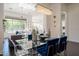 Elegant dining room with glass table, chandelier, and view of living room and outdoors at 7703 E Overlook Dr, Scottsdale, AZ 85255