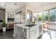 Bright, modern kitchen features marble countertops, stainless steel appliances, and a view to the living room and outside at 7703 E Overlook Dr, Scottsdale, AZ 85255