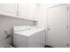 Efficient laundry room with a washer, dryer, and overhead cabinets for convenient storage at 7703 E Overlook Dr, Scottsdale, AZ 85255