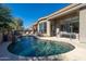 Sparkling backyard pool with a rock waterfall feature and covered patio seating area at 7703 E Overlook Dr, Scottsdale, AZ 85255