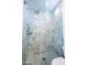 Marble tiled shower enclosure with a frameless glass door and rain shower head at 7703 E Overlook Dr, Scottsdale, AZ 85255