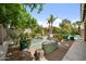 Lush backyard featuring garden beds, mature trees, and a sparkling pool at 824 E Chelsea Dr, San Tan Valley, AZ 85140