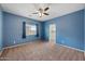 Blue bedroom with a ceiling fan, carpet, a window with curtains and easy access to the closet at 824 E Chelsea Dr, San Tan Valley, AZ 85140