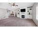 Carpeted bonus room features built-in cabinets, a fireplace, and a ceiling fan at 824 E Chelsea Dr, San Tan Valley, AZ 85140