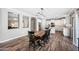 Open-concept dining area with a dark wood table, complementing the wood-style tile flooring, and a stylish light fixture at 824 E Chelsea Dr, San Tan Valley, AZ 85140