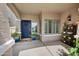Inviting front porch with a blue door, window, and space for potted plants and outdoor decoration at 824 E Chelsea Dr, San Tan Valley, AZ 85140