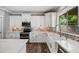 Bright kitchen features white cabinets, stainless steel appliances, farm sink, and decorative backsplash tiles at 824 E Chelsea Dr, San Tan Valley, AZ 85140