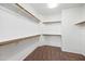 Neutral colored walk-in closet with wood rods and built in shelving; ideal storage and organization at 824 E Chelsea Dr, San Tan Valley, AZ 85140