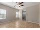 This bedroom features a ceiling fan and tiled floor with an open arched entrance to the bathroom at 10245 W Parkway Dr, Tolleson, AZ 85353