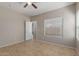 Bedroom featuring a ceiling fan, tiled floor and a large window at 10245 W Parkway Dr, Tolleson, AZ 85353