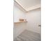 Spacious walk-in closet featuring wooden rods, shelving, and modern gray flooring at 1200 W Boxelder Cir, Chandler, AZ 85224