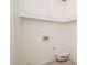 Bright laundry room with tile flooring, washer and dryer hookups and overhead storage at 1200 W Boxelder Cir, Chandler, AZ 85224