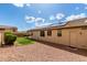 A cozy backyard with green grass, small bushes, and solar panels on the roof of the home at 12057 W Ashby Dr, Peoria, AZ 85383