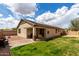Spacious backyard featuring a covered patio, lush green grass, and solar panels on the roof at 12057 W Ashby Dr, Peoria, AZ 85383