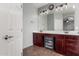 Bathroom with a long vanity with double sinks, lots of mirrors, and warm, inviting lighting at 12057 W Ashby Dr, Peoria, AZ 85383