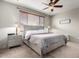 Cozy bedroom with neutral walls, carpeted floors, ceiling fan, and a large window with wood blinds at 12057 W Ashby Dr, Peoria, AZ 85383