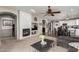 Cozy living room with a fireplace, television, and easy access to the dining area and kitchen at 12057 W Ashby Dr, Peoria, AZ 85383