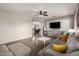 Bright living room with cozy seating, a ceiling fan, and a mounted flatscreen TV at 12057 W Ashby Dr, Peoria, AZ 85383