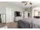 Spacious main bedroom features a ceiling fan, television, ensuite bathroom, and neutral toned carpet at 12057 W Ashby Dr, Peoria, AZ 85383