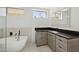 Modern bathroom with a soaking tub, black marble countertops, and sleek vanity at 12639 N 136Th St, Scottsdale, AZ 85259