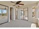 Bright bedroom featuring carpet floors, a ceiling fan, and sliding door access to the covered patio at 12639 N 136Th St, Scottsdale, AZ 85259