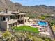 Custom home features lush green grass, swimming pool with waterfall feature, and desert landscape at 12639 N 136Th St, Scottsdale, AZ 85259