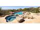An in-ground pool and spa featuring a rock waterfall design with a stone paver patio at 12639 N 136Th St, Scottsdale, AZ 85259