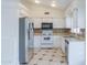 A kitchen with white cabinetry, stainless steel appliances, and tiled backsplash and floor at 1297 E Avenida Kino --, Casa Grande, AZ 85122
