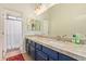 Bathroom with double sink, blue vanity, and marble countertop at 14022 W Hope Dr, Surprise, AZ 85379